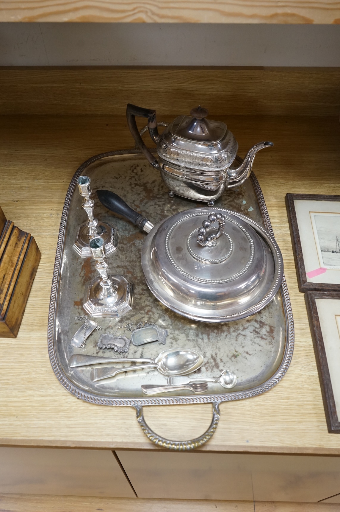 A pair of white metal candlesticks, a silver plated teapot circular tureen and cover spoons and forks and four spirit labels and large tray. Tray 73cm wide